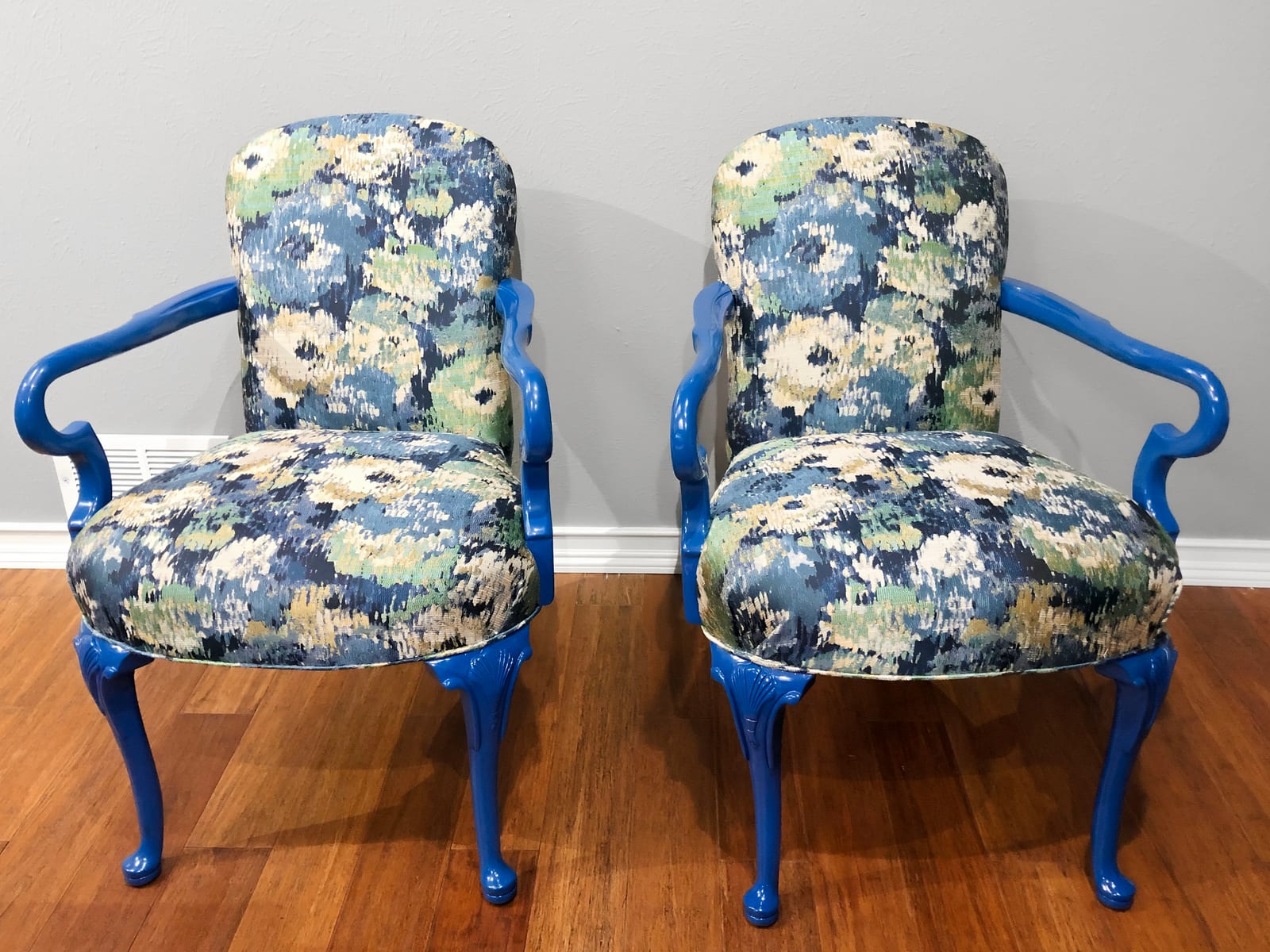 The same two chairs reupholstered in blue and cream floral fabric with the frames painted blue