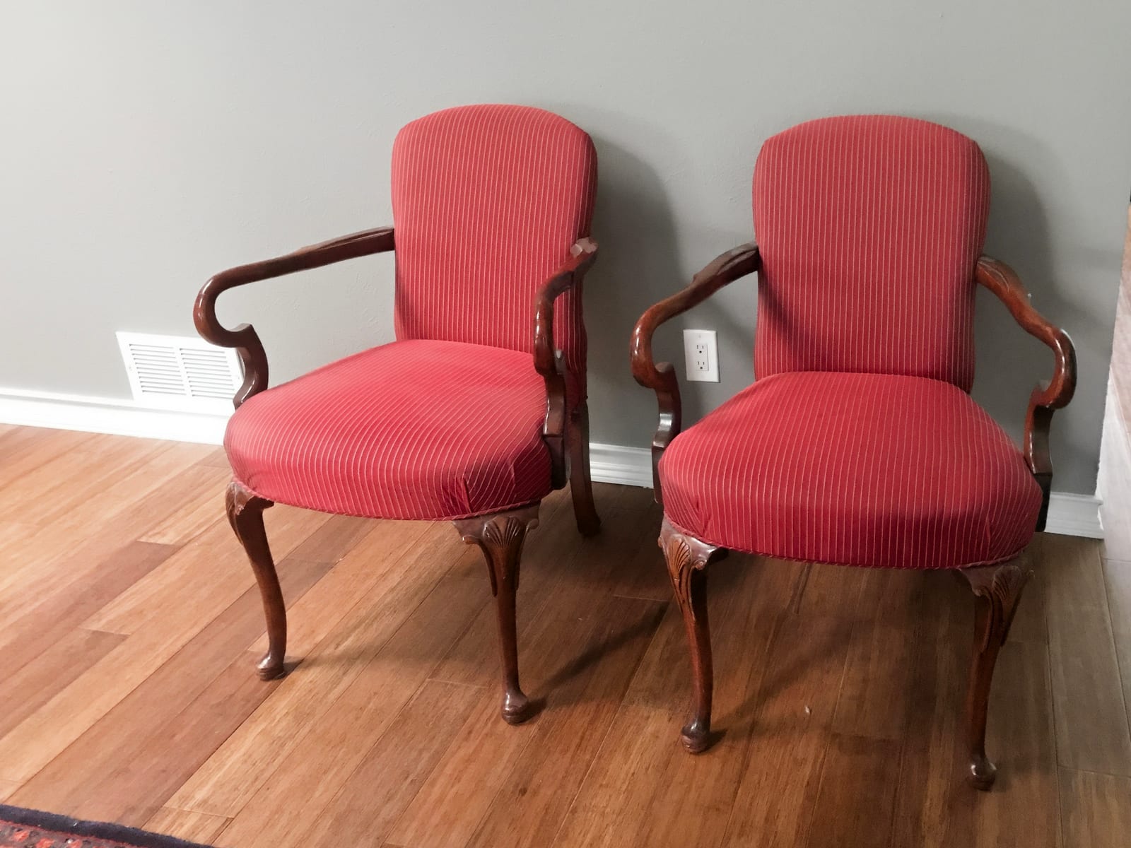 Two armchairs in plain red upholstery with natural wood frames