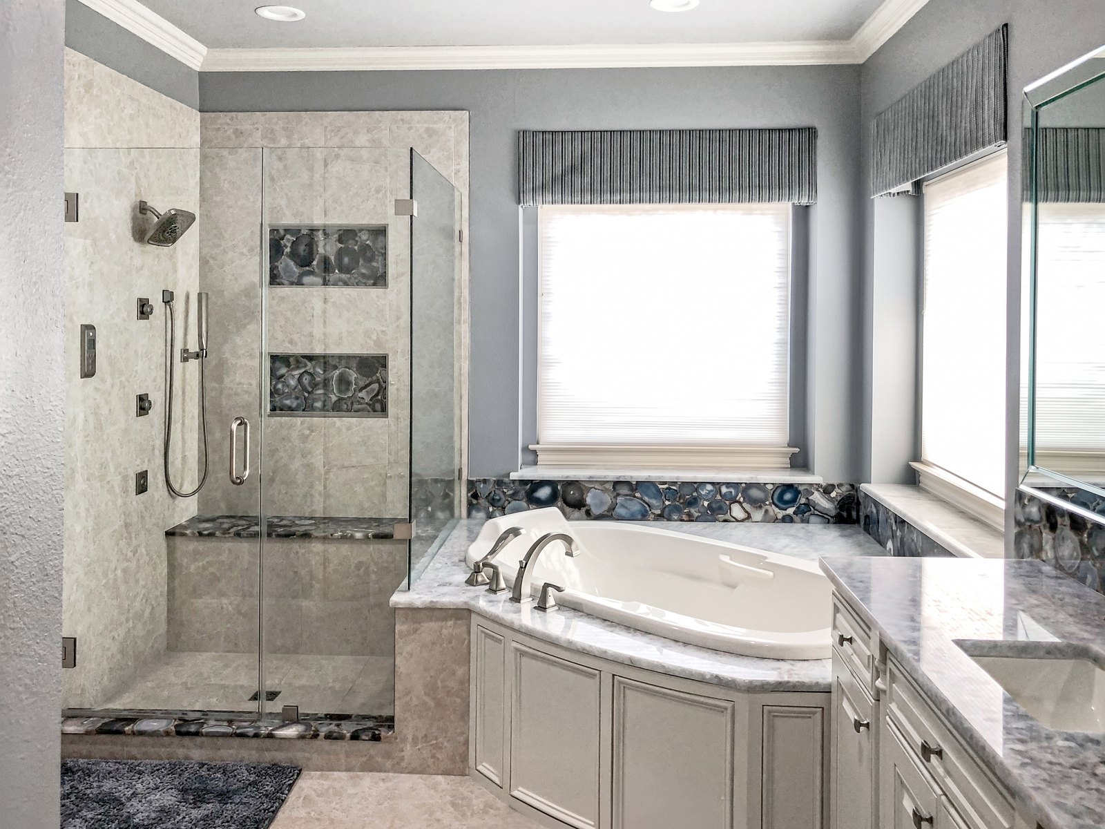 Walk-in shower with agate slice niches beside a soaking tub
