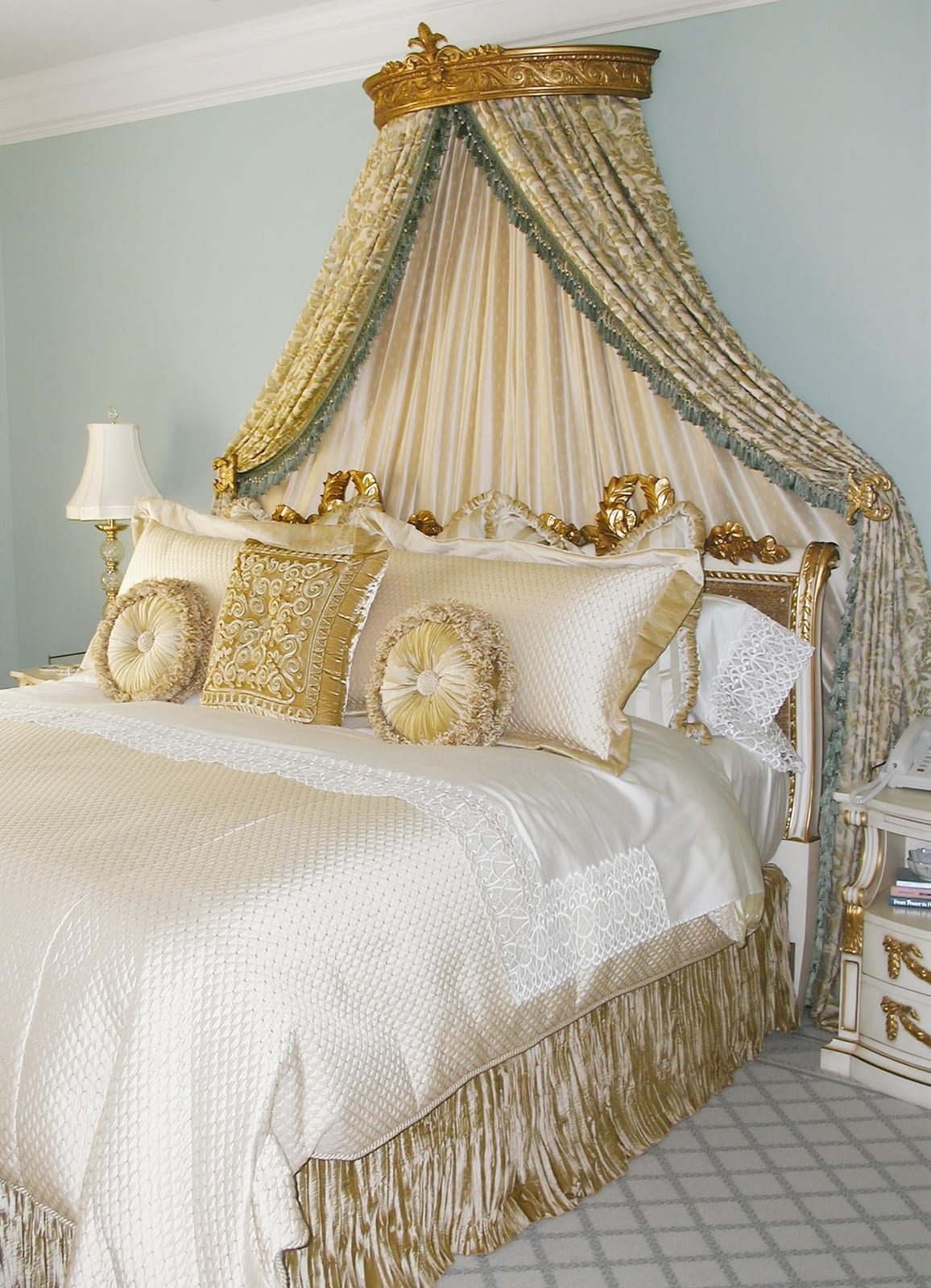 Bed crowned with a gilded corona and cascading drapery