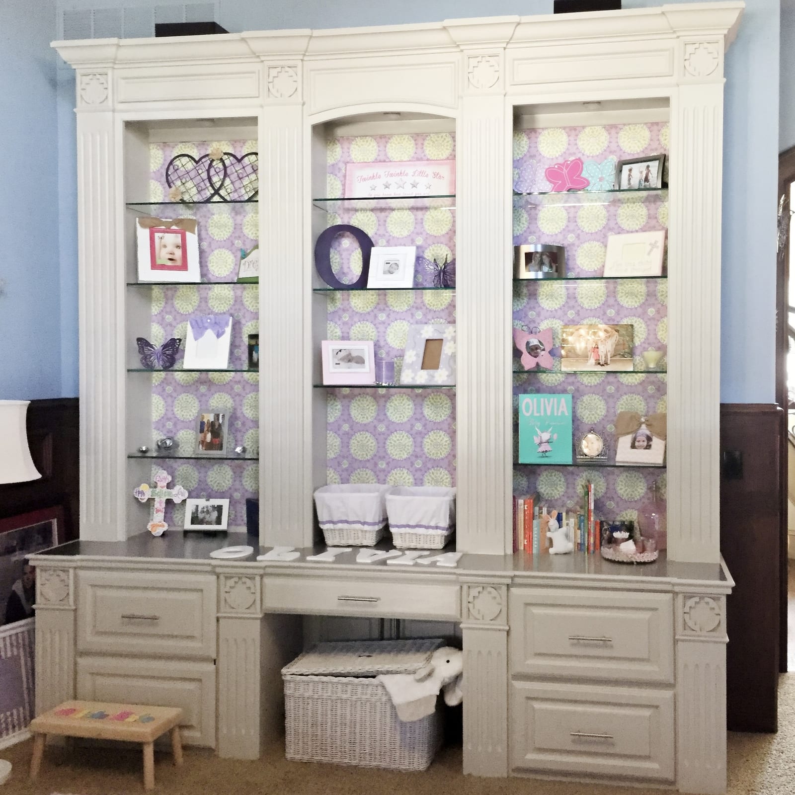 Built-in bookshelves with fabric-backed panels and a stainless steel top