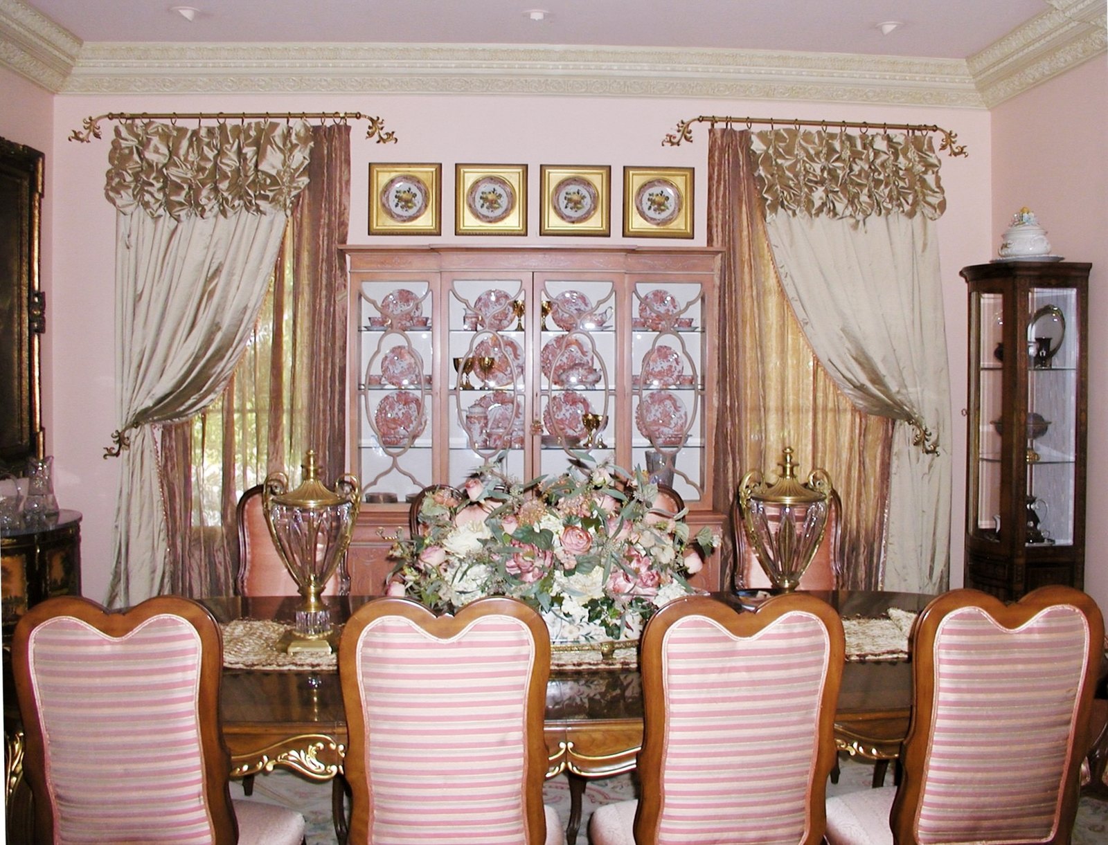 Formal dining room with rose striped chairs and a rose-painted china cabinet