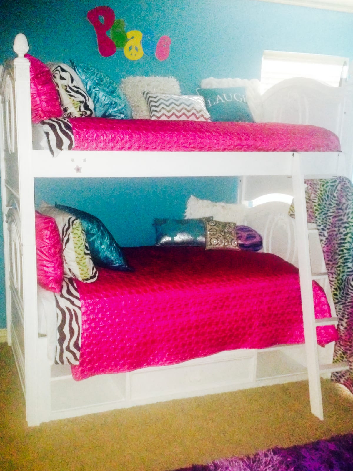 Bedroom with white bunk beds, hot pink bedding and a turquoise wall