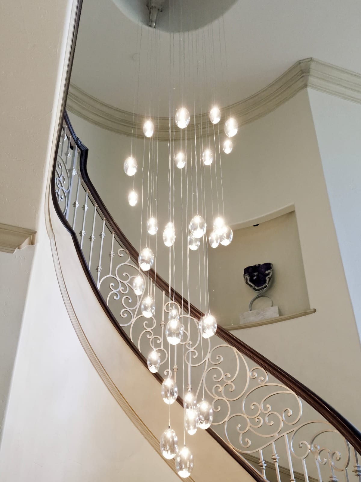 Curved staircase with a cascading Swarovski crystal chandelier