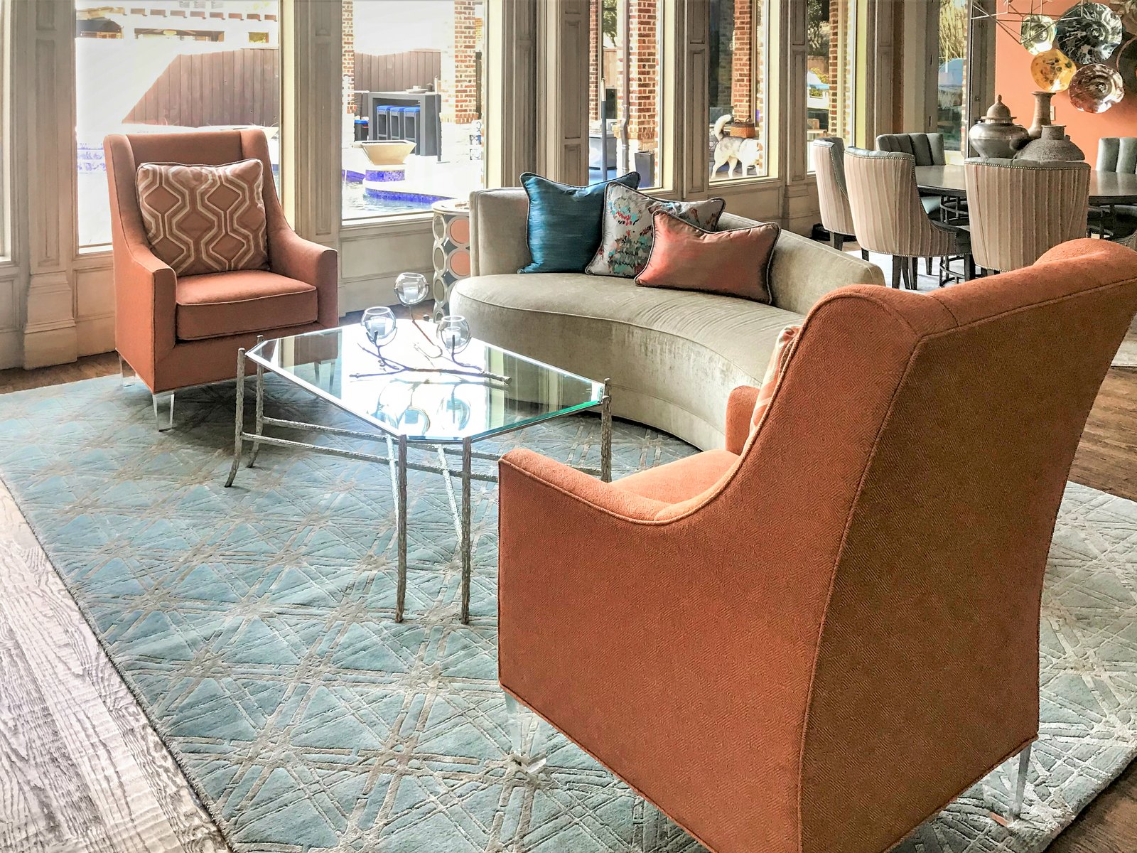 Living room with rust accent chairs and glass coffee table