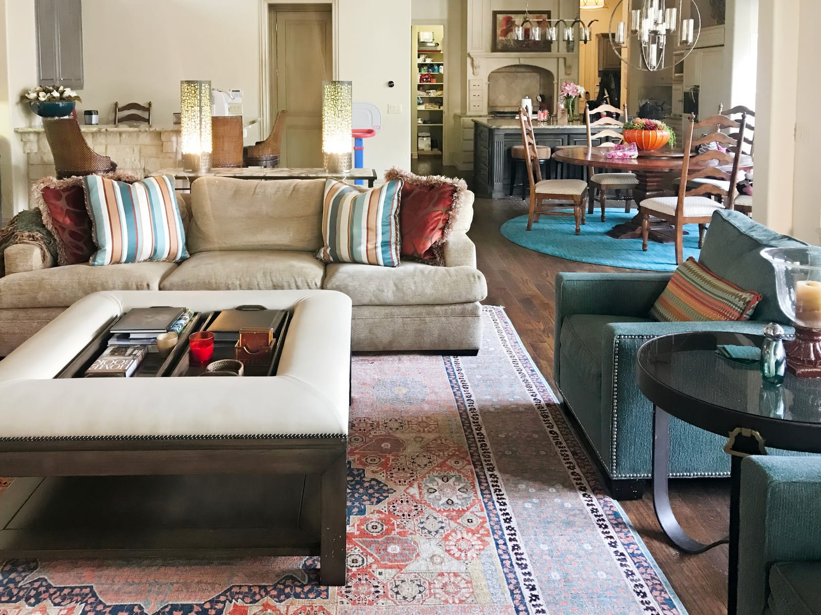 Open living and dining space with layered rugs and striped pillows