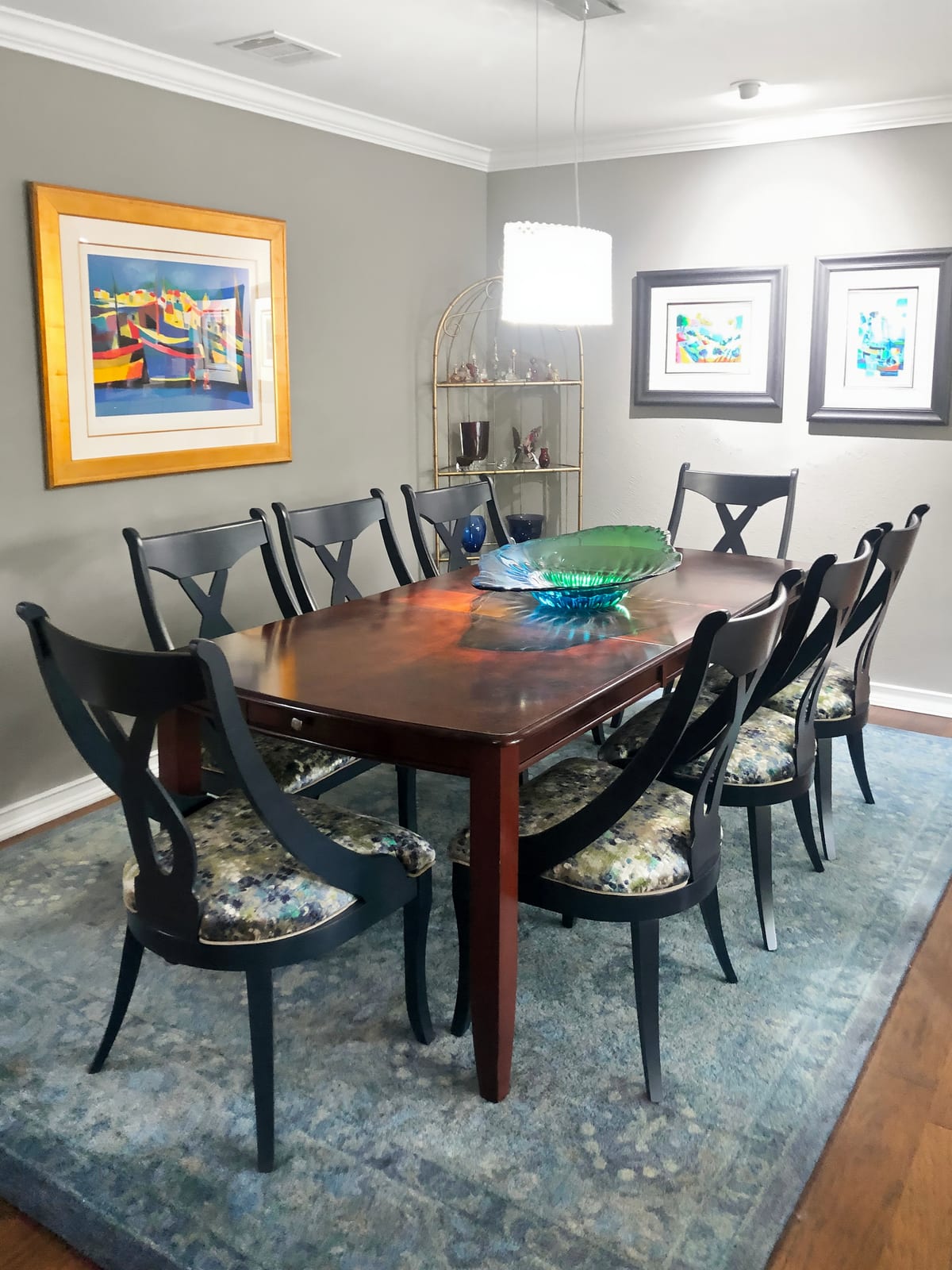 Dining room with a dark table, patterned seats and a blown-glass centerpiece
