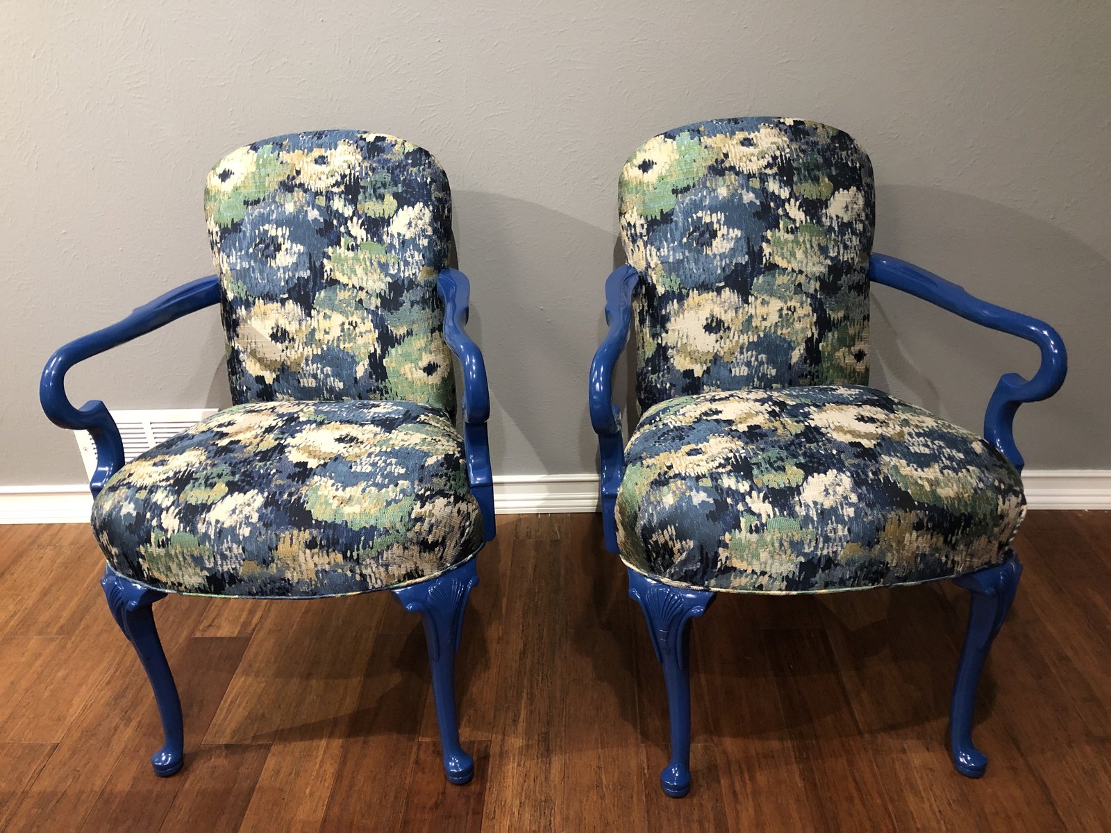 The same two chairs reupholstered in blue and cream floral fabric with the frames painted blue