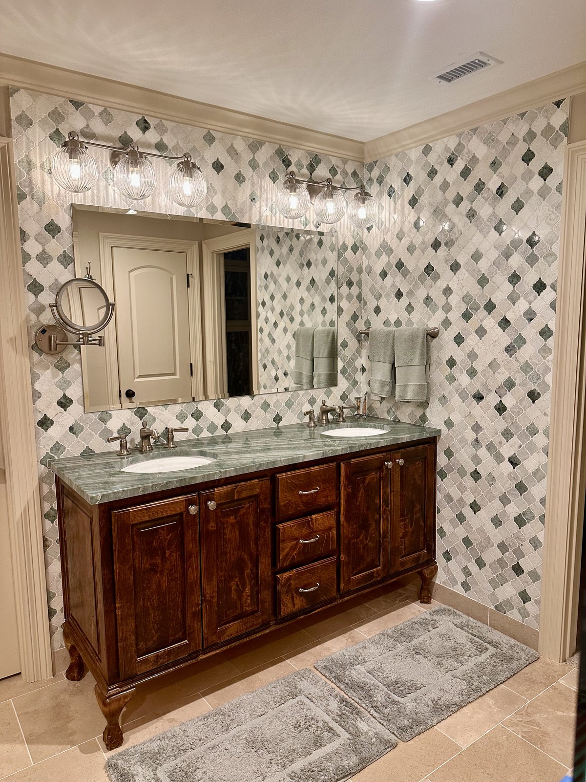 Double vanity against a full wall of arabesque mosaic tile