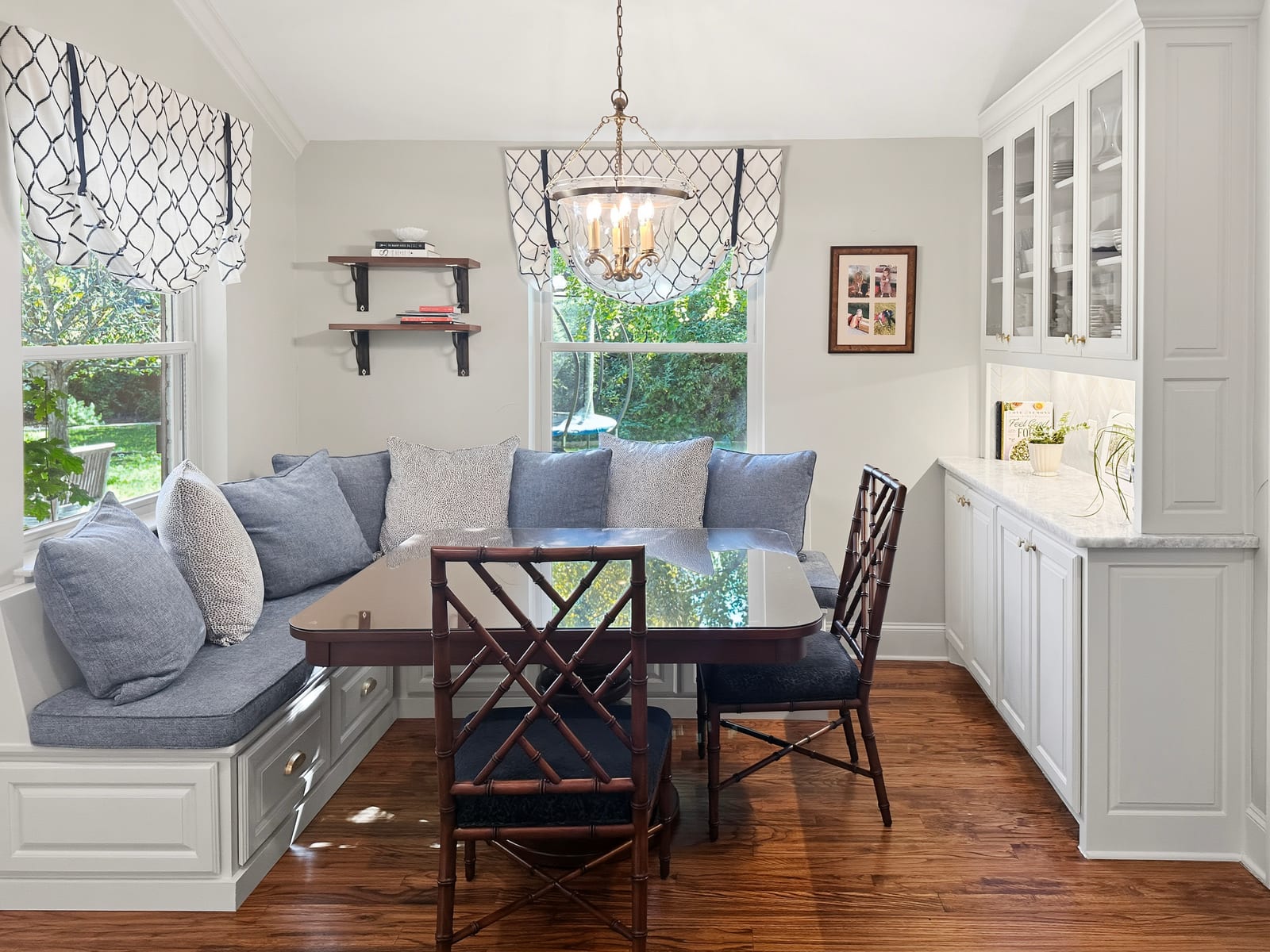 Built-in breakfast banquette with navy cushions and roman shades