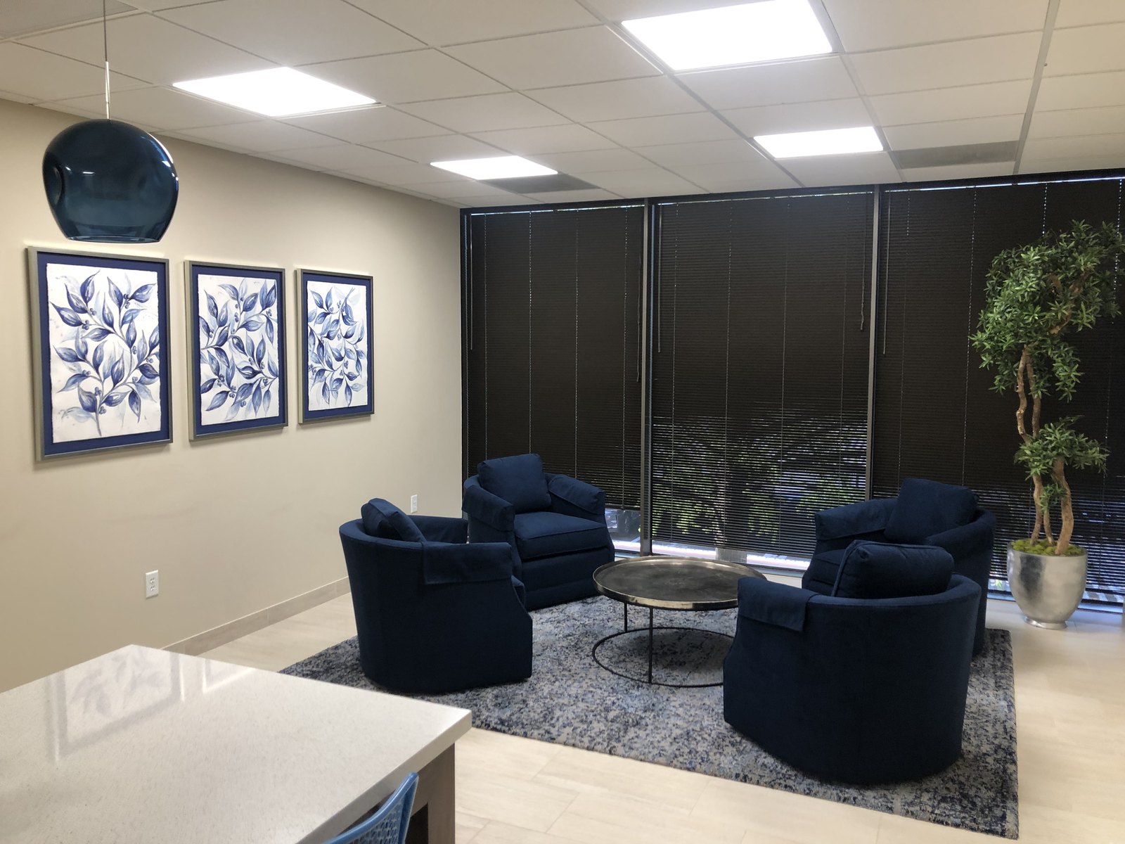 Tenant lounge in a Dallas office building with seating groups and layered lighting