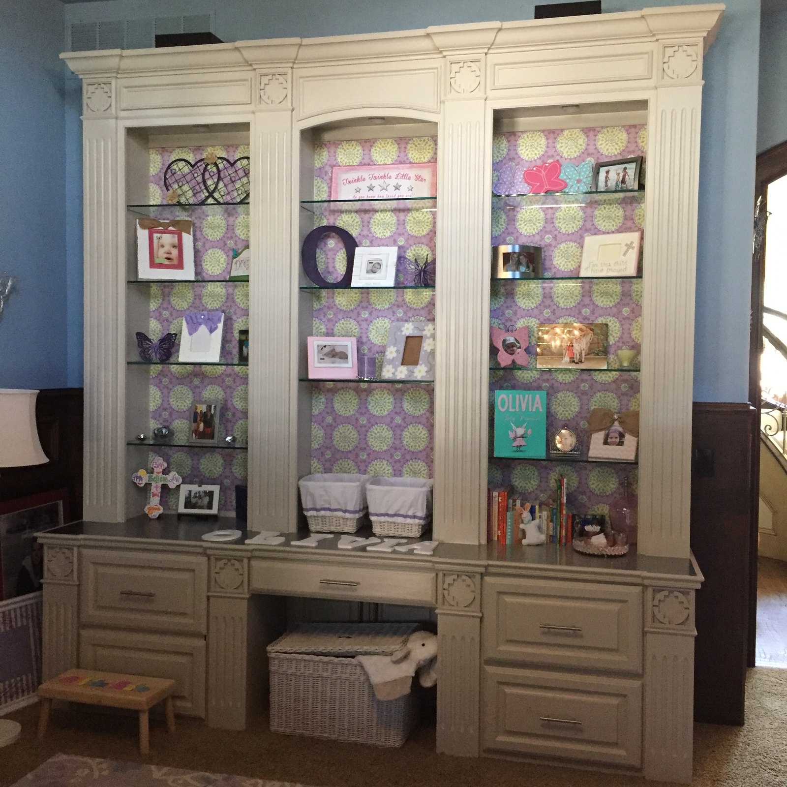 Reading corner with a side chair beside styled built-in bookshelves