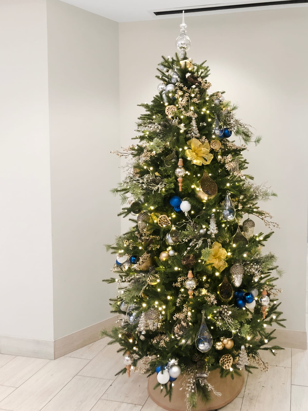 Office lobby Christmas tree in gold, silver and blue with woodland ornaments