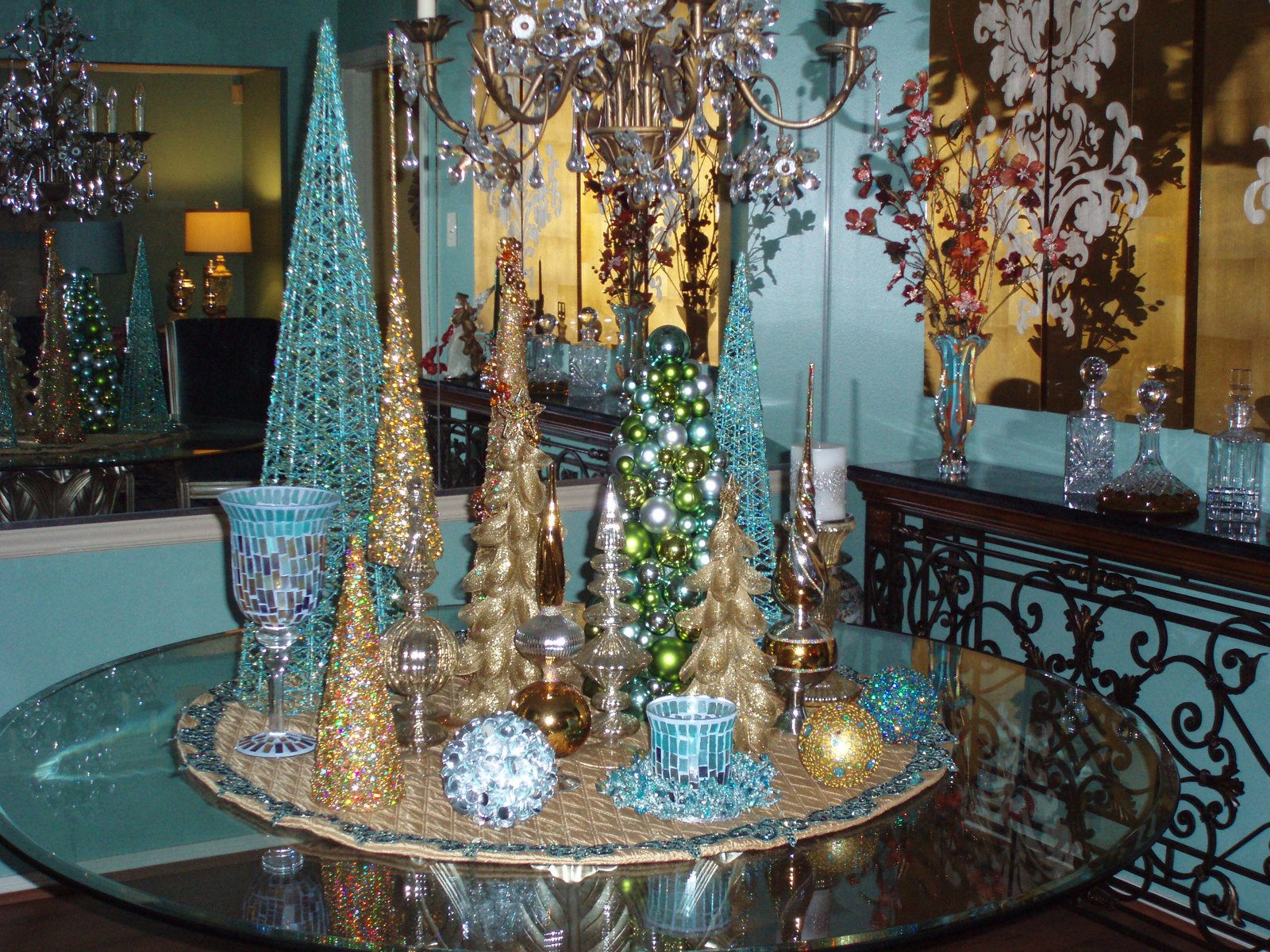 Holiday tablescape with mercury glass trees and candlelight on a glass table