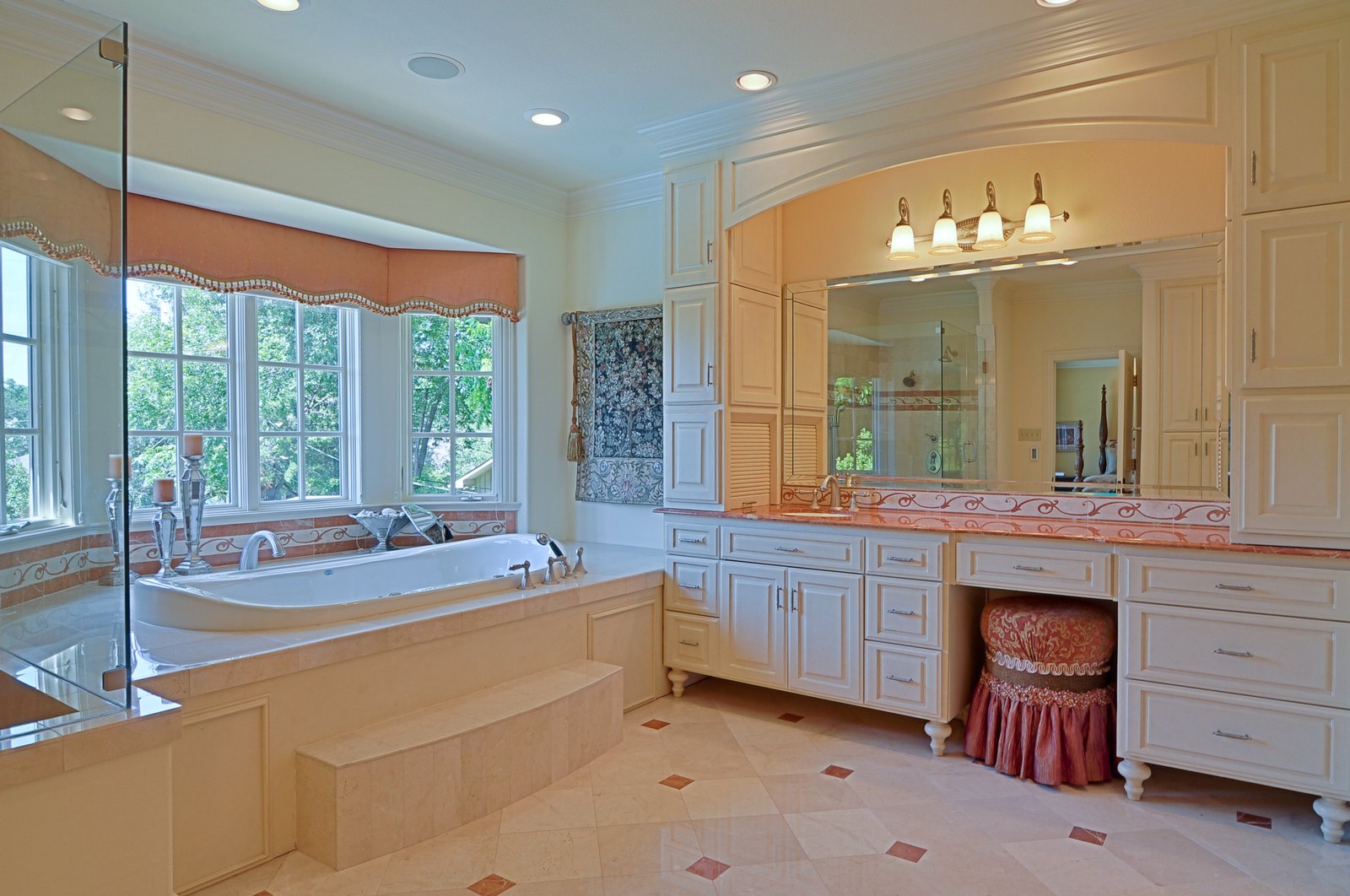 Bathroom with a corner tub, long vanity run and window seat